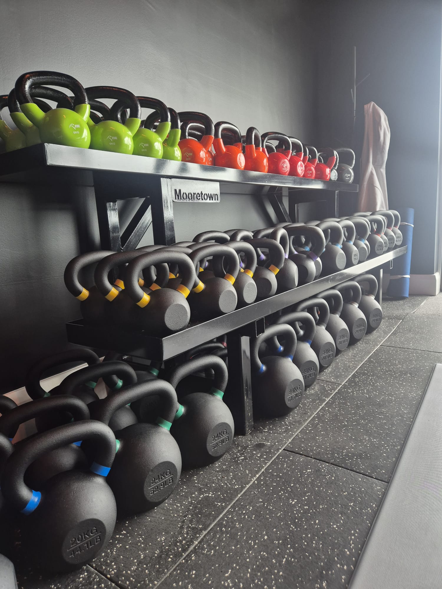 Racked kettlebells ranging from light to heavy at Almost Always