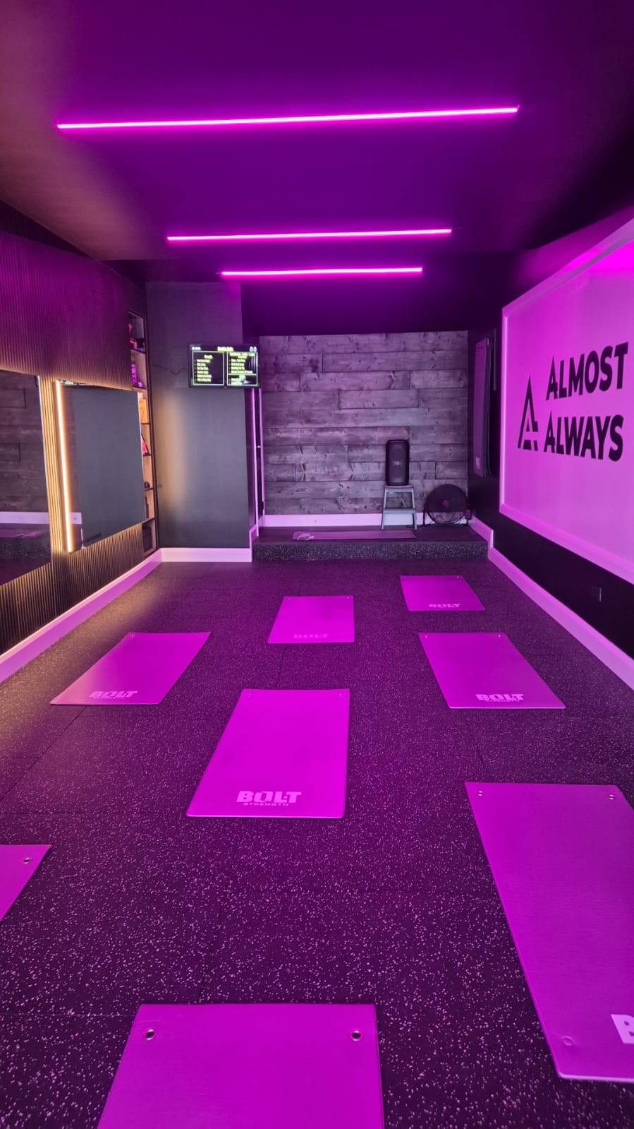 Almost Always studio floor set up with mats under purple neon lighting